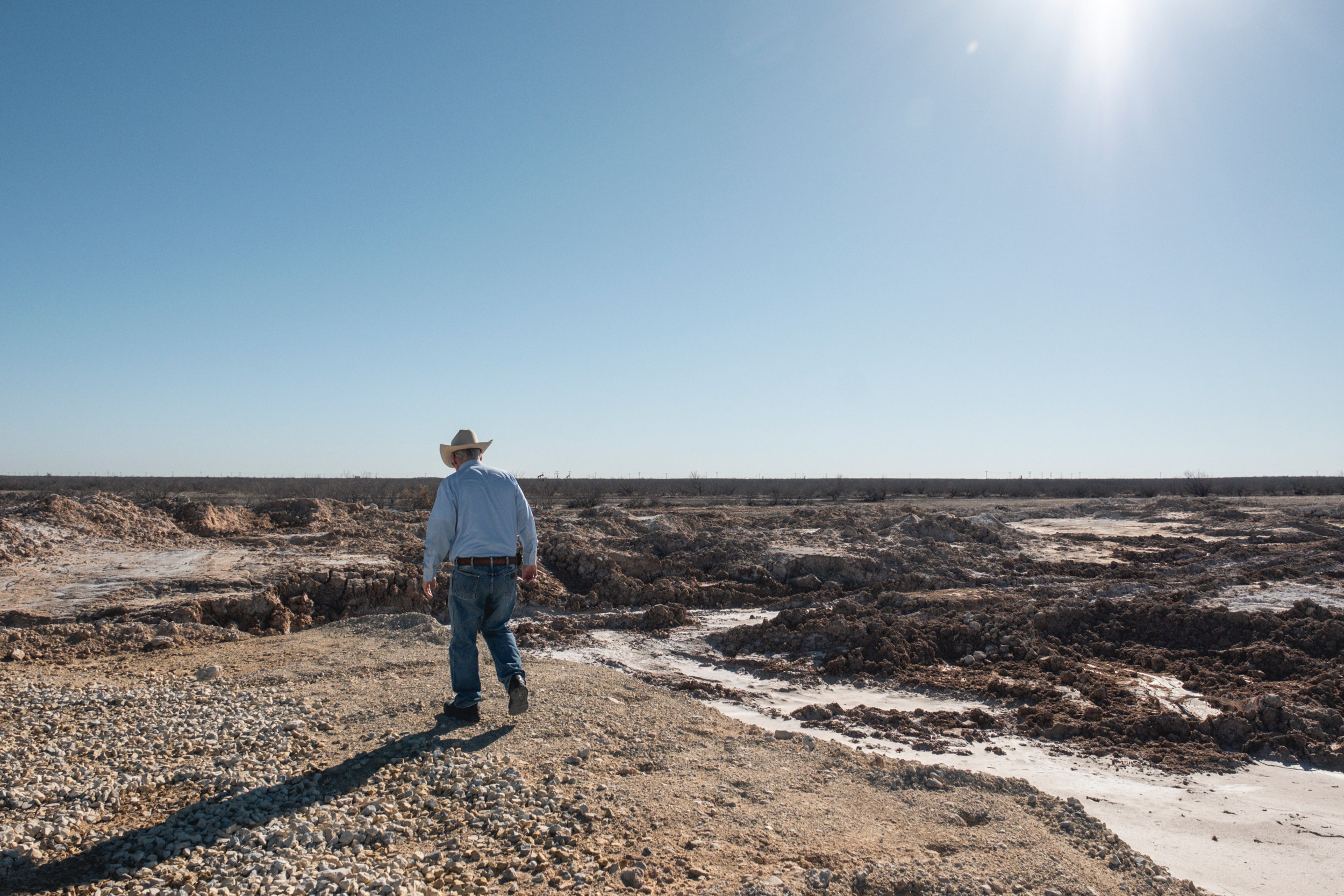 Bill Wight walks on his property, ravaged by rupturing salt water from an abandoned well. Credit: Sarah M. Vasquez/The Texas Tribune