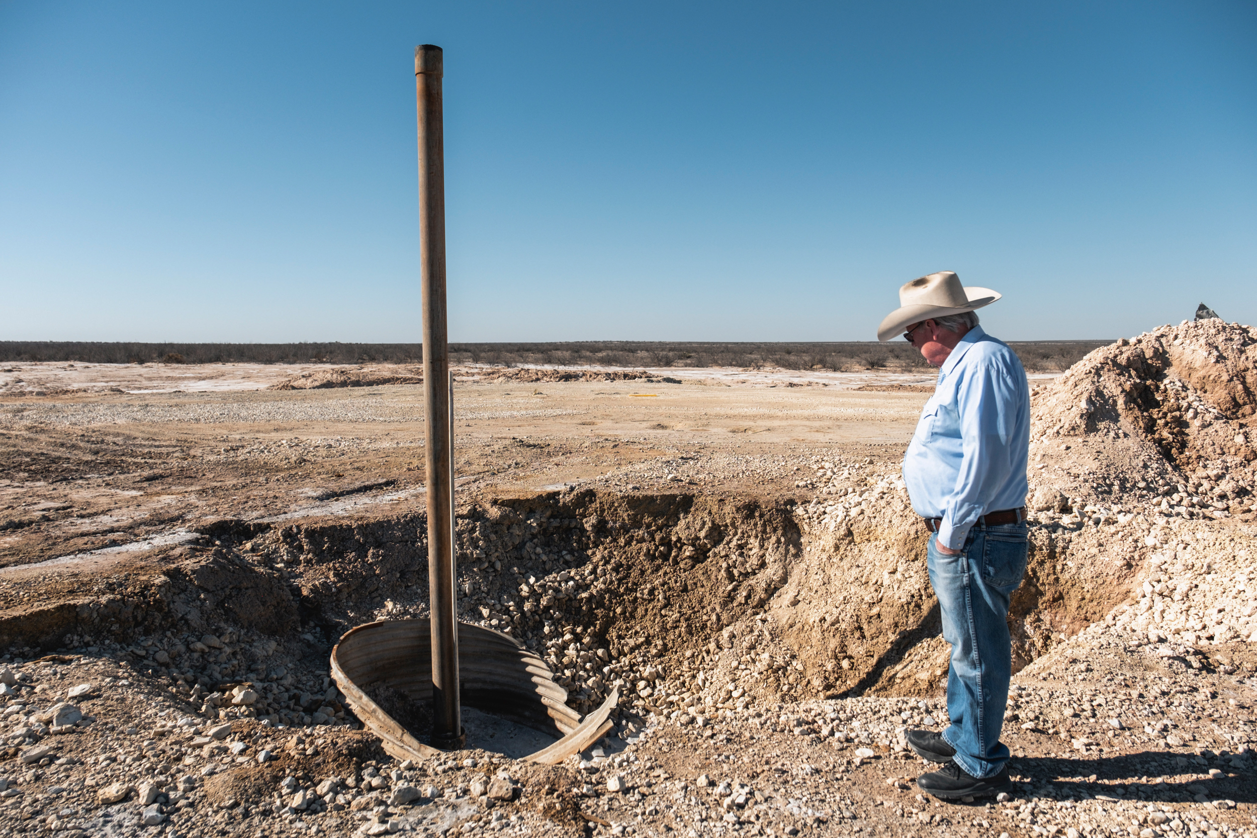 Bill Wight looks at the well that leaked enormous volumes of saltwater on his property. It took crews over a month to seal the well and stop the leak. Credit: Sarah M. Vasquez/The Texas Tribune