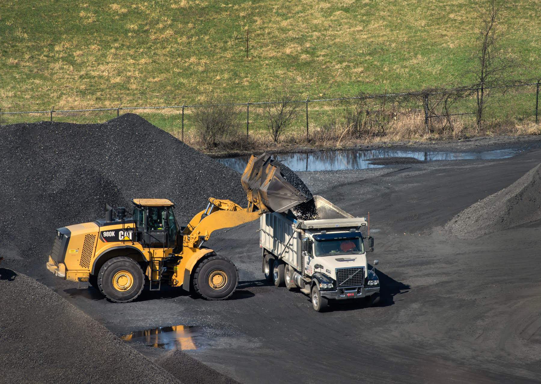 A bulldozer loads coke to be hauled away for steel production. Credit: Scott Goldsmith/Inside Climate News