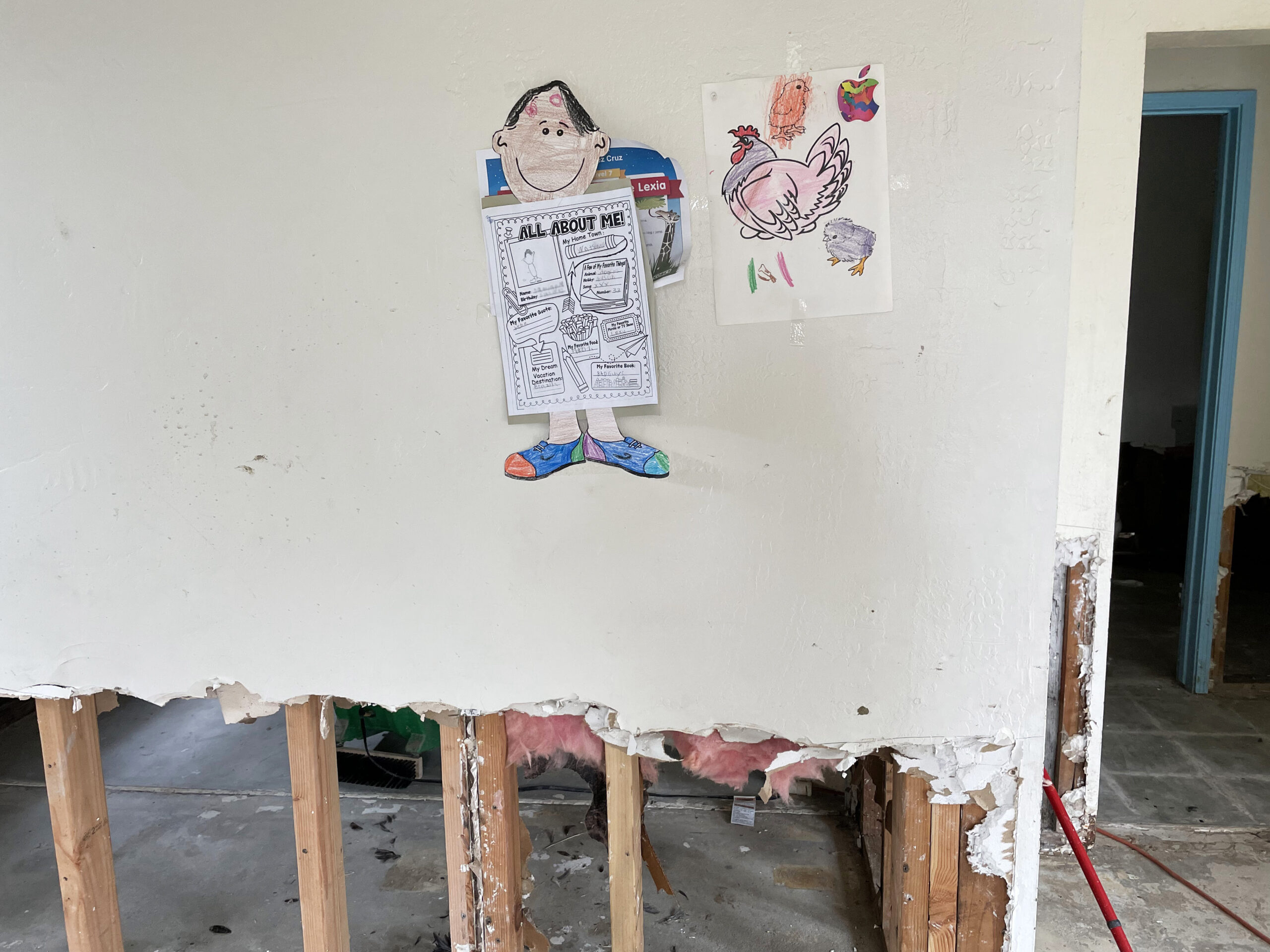 Las tareas escolares de uno de los hijos de Emilio Vásquez todavía cuelgan en la pared de la casa que alquilaba con su familia, después de que la desastrosa inundación de Pájaro la volviera inhabitable. La familia todavía no sabe cuándo podrán regresar. Crédito: Liza Gross