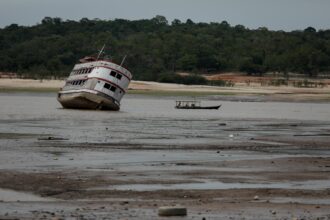 A ferry boat is seen stranded at the Marina do Davi, a docking area of the Negro River in the city of Manaus, Amazonas State, northern Brazil, on October 16, 2023. The Negro River is facing the worst dry season of the last decades in the Amazon rainforest. Credit: Michael Dantas/AFP via Getty Images