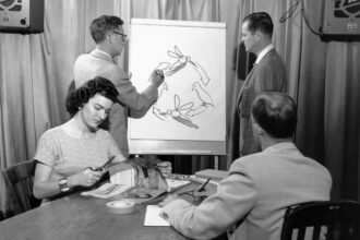In 1958, staff members at a newly created agency called the Centers for Disease Control and Prevention practice drawing training aids for teaching about vector-borne diseases, including malaria; in this case, one staff member draws the life cycle of a mosquito on a whiteboard. Image courtesy CDC. Credit: Smith Collection/Gado/Getty Images.