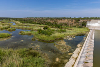 Stagnant water sits below the dry spillway of Falcon Dam in Starr County on Aug. 18, 2022. Credit: Michael Gonzalez/The Texas Tribune