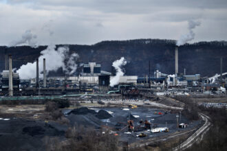 A coke storage area is seen as steam rises from the quench towers at the Clairton Coke Works on Jan. 21, 2020, in Clairton, Pa. Credit: Brendan Smialowski/AFP via Getty Images