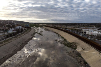 An aerial view of the Tijuana River crossing the Mexico-U.S. border on March 14, 2020. Credit: Guillermo Arias/AFP via Getty Images