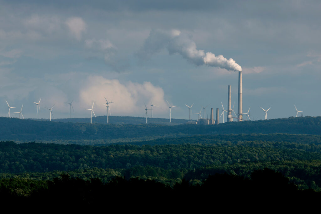 Turbines from the Mount Storm Wind Farm stand in the distance behind the Dominion Mount Storm power station in West Virginia. Credit: Chip Somodevilla/Getty Images