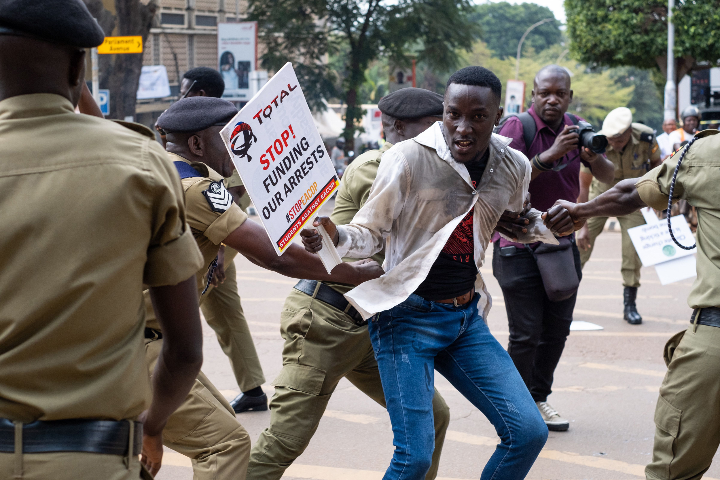 Ugandan police officers arrest an environmental activist in front of the Parliament of Uganda during a protest against the East African Crude Oil Pipeline (EACOP) in Kampala on Sept. 15, 2023. Credit: Badru Katumba/AFP via Getty Images