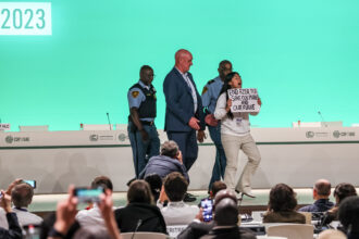 A young activist of American indigenous origins, Licypriya Kangujam, is removed by security after she forced herself onto the stage in a protest against fossil fuels extraction during COP28's "Uniting on the Pathway to 2030 and Beyond" session on December 11, 2023 in Dubai. Credit: Dominika Zarzycka/NurPhoto via Getty Images