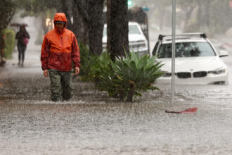A person walks along a flooded street as a powerful long-duration atmospheric river storm impacts California on Feb. 4 in Santa Barbara. Credit: Mario Tama/Getty Images