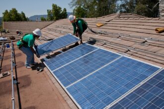 Two solar workers install solar panels on home in Oak View, Southern California. Credit: Joe Sohm/Visions of America/Universal Images Group via Getty Images