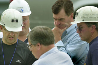 In July 2002, then-Pennsylvania Gov. Mark Schweiker, second from right, listens to a progress report on rescue efforts at Quecreek Mine in Somerset, Pennsylvania. At right is Joseph A. Braffoni, of the Bureau of Deep Mine Safety, second from left is Larry Winckler, center is David Hess, Pennsylvania secretary of the Department of Environmental Protection and at left is Jeffery Stanchek a mine rescue instructor for the DEP. They were coordinating efforts to reach nine miners trapped for three days. Credit: Gene J. Puskar/ AFP via Getty Images.