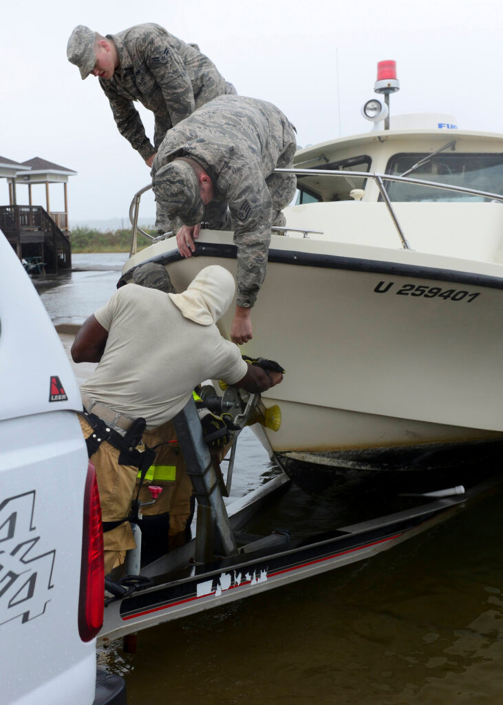 U.S. Air Force airmen align a fire and rescue boat with a hitch to tow the boat away from the Langley Marina at Langley Air Force Base, Virginia on Oct. 1, 2015. Heavy precipitation, high winds, storm surges, and flooding associated with Hurricane Joaquin caused personnel to take action. Credit: Derek Seifert/U.S. Air Force