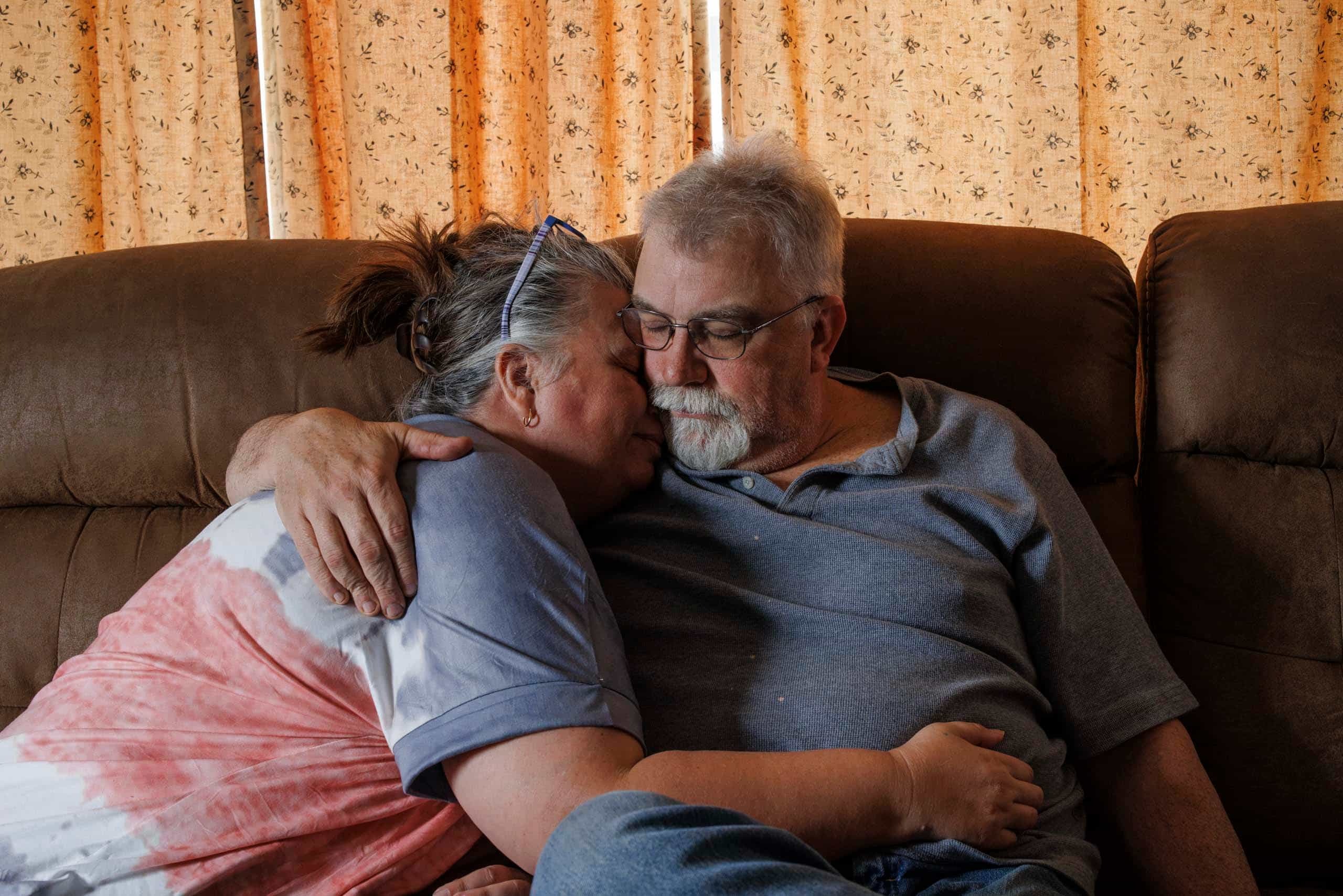 Abby and Scott Tennant embrace at the house where the family relocated in Paden City, West Virginia, after experiencing illnesses when EQT expanded operations in the hollow they called home. Credit: Quinn Glabicki/PublicSource