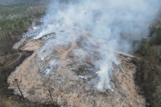 This December 2022 photo shows smoke and open flames at the landfill site near Moody, Alabama. In the time since, the fire has continued to burn underground. Credit: Courtesy of Moody Fire Department