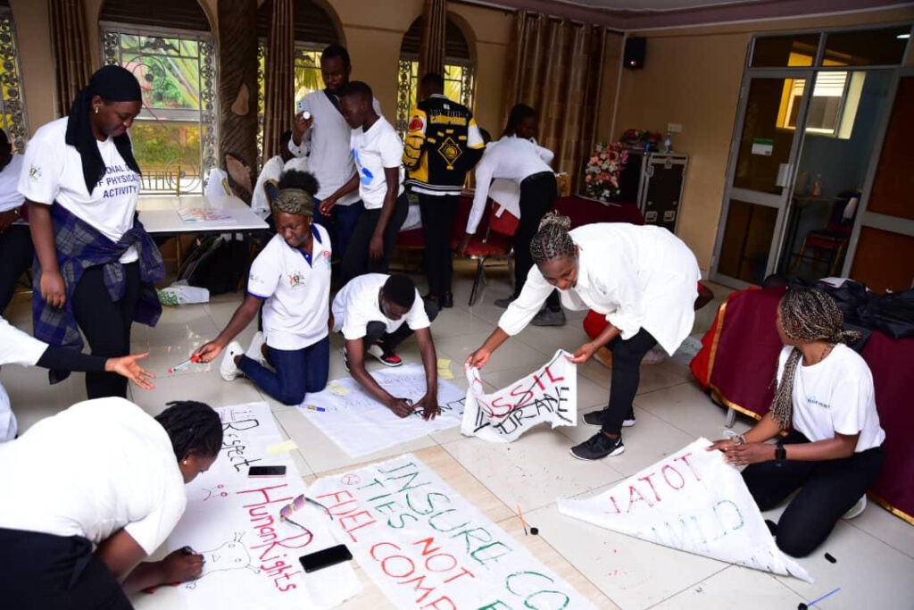 Insure Our Future campaigners in Kampala, Uganda worked on banners focused on ending insurance underwriting of fossil fuels. Credit: Mulasa Peter