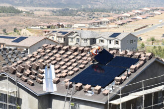 Workers install solar panels on the roofs of homes under construction south of Corona, California on May 3, 2018. Credit: Will Lester/Inland Valley Daily Bulletin via Getty Images